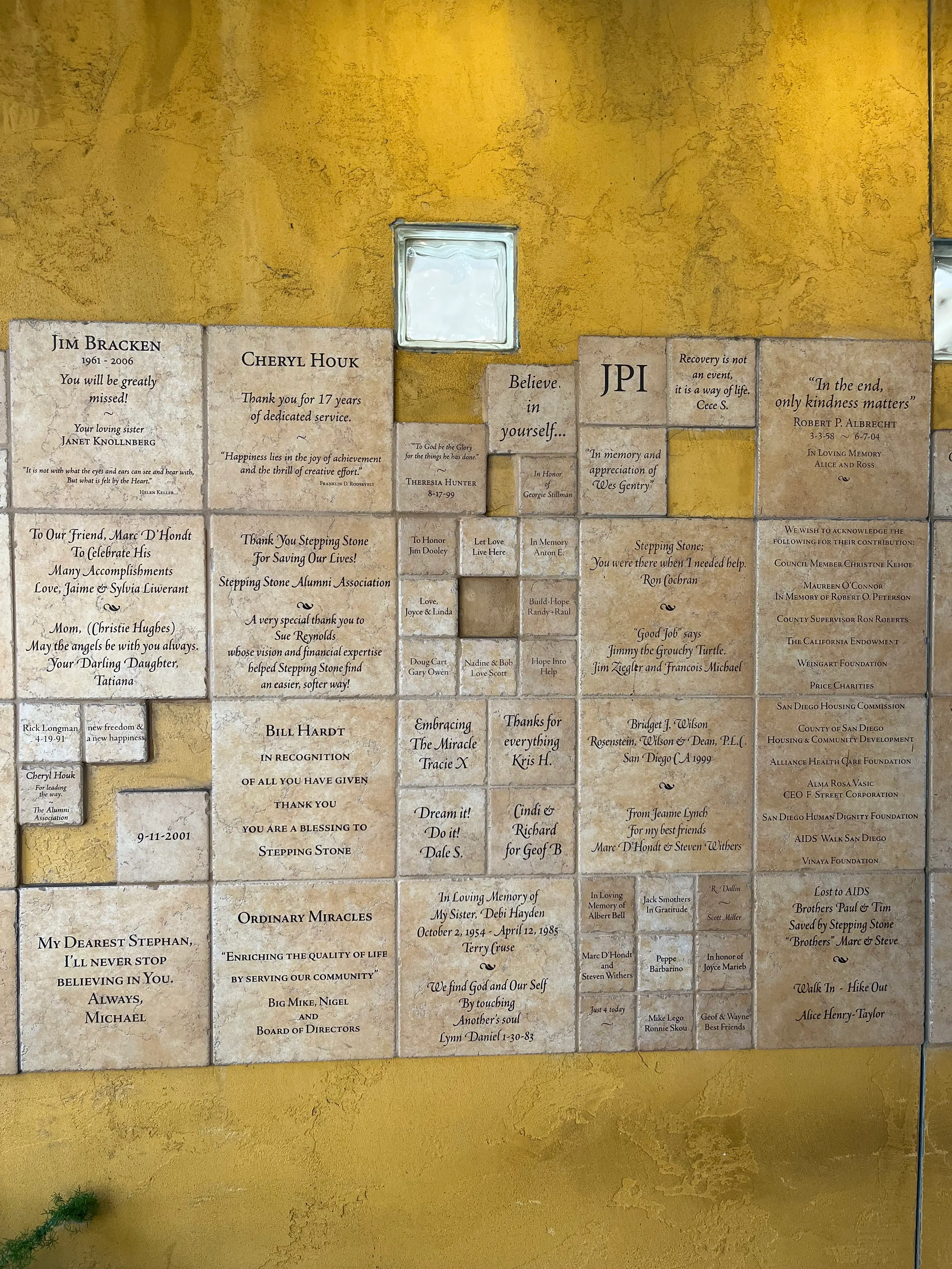 A wall of engraved memorial and tribute tiles at the Stepping Stone residential facility